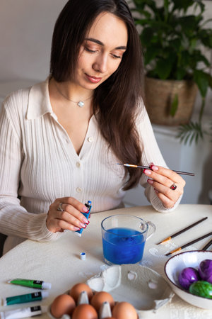 Beautiful woman dyeing Easter eggs. Woman holding Easter eggs in her hands. High quality photoの写真素材