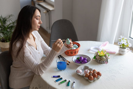 Beautiful woman dyeing Easter eggs. Woman holding Easter eggs in her hands. High quality photo