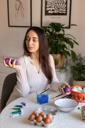 Beautiful woman dyeing Easter eggs. Woman holding Easter eggs in her hands. High quality photoの写真素材