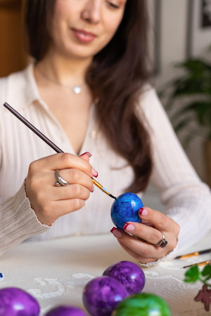 Beautiful woman dyeing Easter eggs. Woman holding Easter eggs in her hands. High quality photoの写真素材