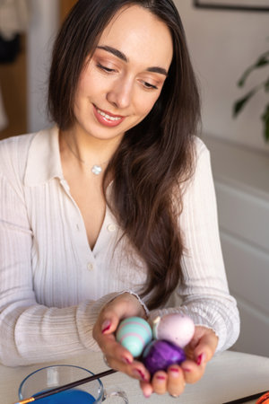 Beautiful woman dyeing Easter eggs. Woman holding Easter eggs in her hands. High quality photoの写真素材