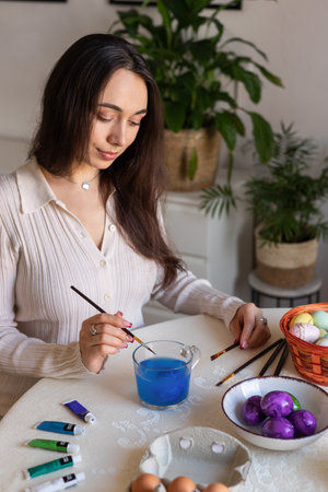 A beautiful woman is decorating Easter eggs. Dyeing Easter eggs at home. High quality photoの写真素材