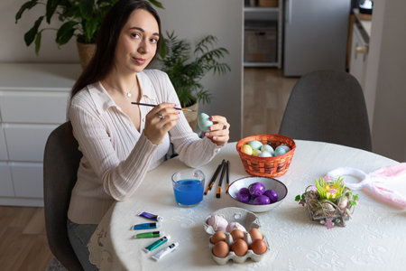 A beautiful woman is decorating Easter eggs. Dyeing Easter eggs at home. High quality photoの写真素材