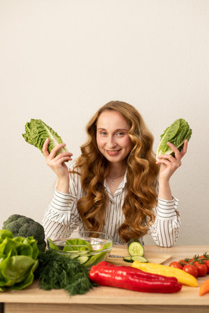 Beautiful woman holding lettuce leaves in her hands. Proper nutrition at home. Vegetarian food. High quality photoの写真素材