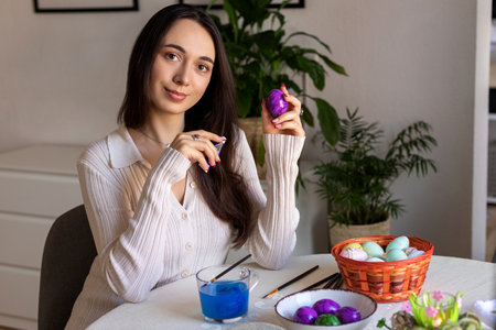 A beautiful woman is decorating Easter eggs. Dyeing Easter eggs at home. High quality photoの写真素材