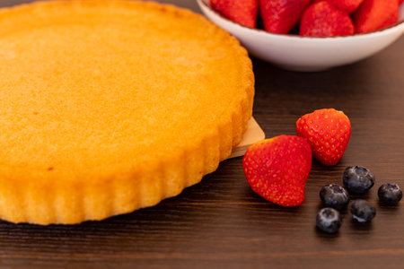 Sponge cake on the table. The process of making strawberry pie. Strawberries and blueberries on the table. High quality photoの写真素材