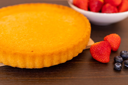 Sponge cake on the table. The process of making strawberry pie. Strawberries and blueberries on the table. High quality photoの写真素材