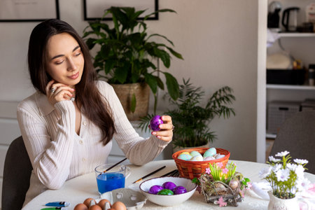 A beautiful woman is decorating Easter eggs. Dyeing Easter eggs at home. High quality photoの写真素材