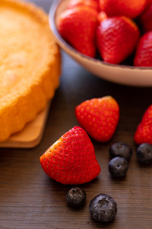 Sponge cake on the table. The process of making strawberry pie. Strawberries and blueberries on the table. High quality photoの写真素材