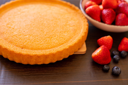 Sponge cake on the table. The process of making strawberry pie. Strawberries and blueberries on the table. High quality photoの写真素材