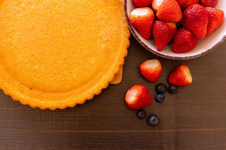 Sponge cake on the table. The process of making strawberry pie. Strawberries and blueberries on the table. High quality photoの写真素材