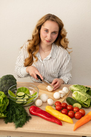 A woman is cutting mushrooms. Vegetarian diet food. High quality photoの写真素材