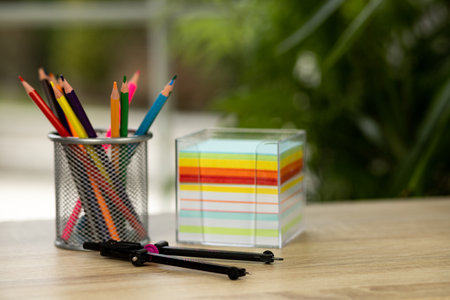 Colored pencils in a stand. Compasses and sheets of paper. Stationery. High quality photoの写真素材