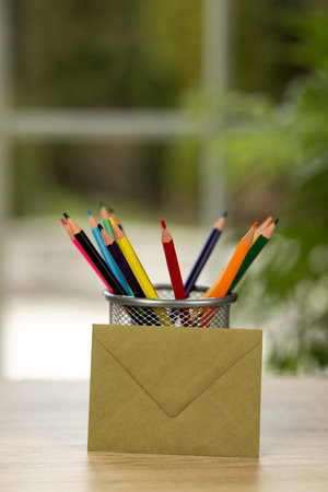 Colored pencils in a stand. Office. Envelope on the table. Envelope and colored pencils. High quality photoの写真素材