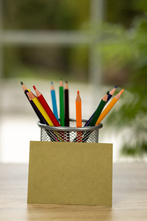Colored pencils in a stand. Office. Envelope on the table. Envelope and colored pencils. High quality photoの写真素材