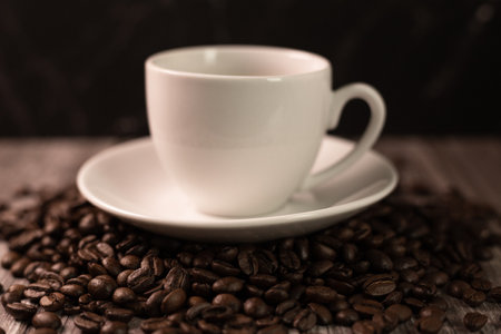 A cup of coffee and coffee beans on a dark background. Roasted coffee beans. High quality photoの写真素材