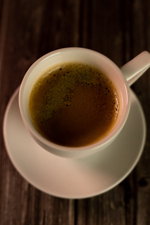 A cup of coffee on a wooden table. View from above. Coffee with foam. High quality photoの写真素材