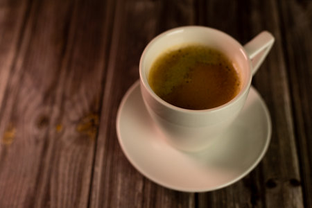 A cup of strong aromatic coffee on a dark background. Coffee in a white cup. High quality photoの写真素材