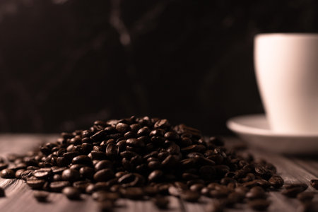 Coffee beans and a cup of coffee on a wooden table. Roasted coffee beans. High quality photoの写真素材
