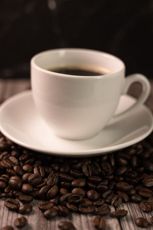 A cup of coffee and coffee beans on a dark background. Roasted coffee beans. High quality photoの写真素材