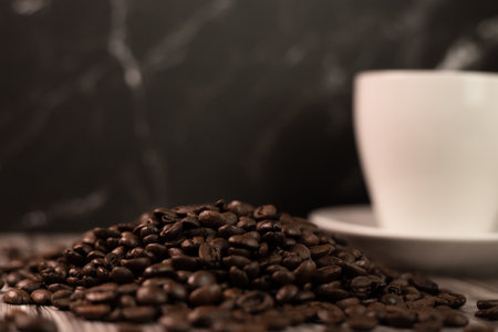 A cup of coffee and coffee beans on a dark background. Roasted coffee beans. High quality photoの写真素材