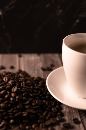 Cup of coffee and coffee beans on a brown background. Black strong coffee. High quality photoの写真素材