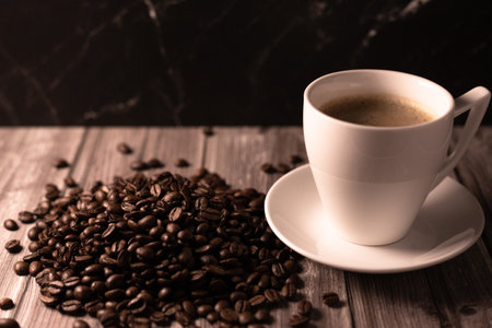 A cup of coffee and coffee beans on a dark background. Roasted coffee beans. High quality photoの写真素材