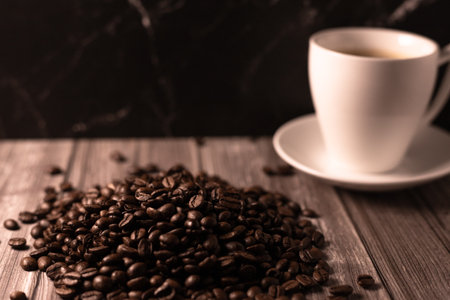 A cup of coffee and coffee beans on a dark background. Roasted coffee beans. High quality photoの写真素材