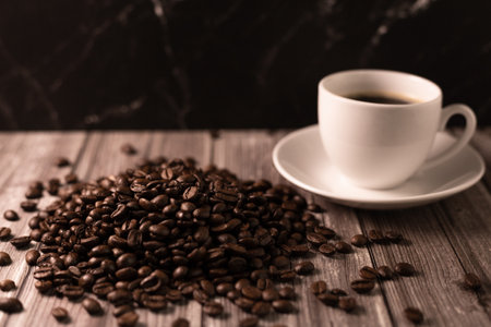 A cup of coffee and coffee beans on a dark background. Roasted coffee beans. High quality photoの写真素材