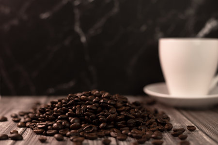 A cup of coffee and coffee beans on a dark background. Roasted coffee beans. High quality photoの写真素材