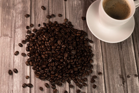 A cup of coffee and coffee beans on a dark background. Roasted coffee beans. High quality photoの写真素材