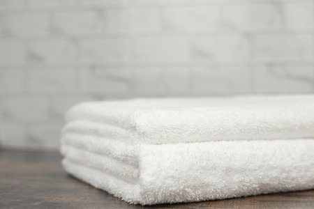 Two white terry towels on a wooden background. Towel in the bathroom. High quality photoの写真素材