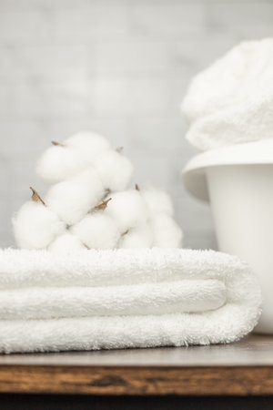Cotton flowers lie on top of towels. A white basin for washing. laundry. Towels. High quality photoの写真素材