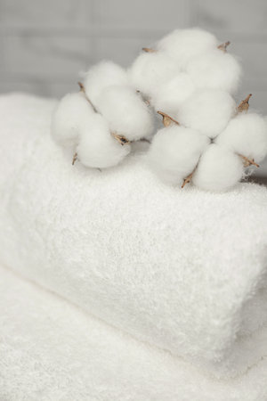 Beautifully folded towels top view. Cotton flowers on a towel. High quality photoの写真素材