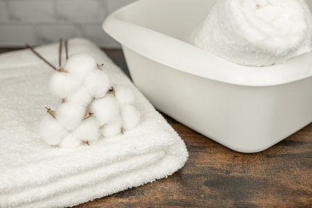 Cotton flowers on a white towel. Washing. A basin for washing. Clean towels. High quality photoの写真素材