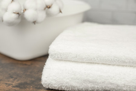 Two white terry towels. Cotton flowers in a white basin. Natural fabrics. High quality photoの写真素材
