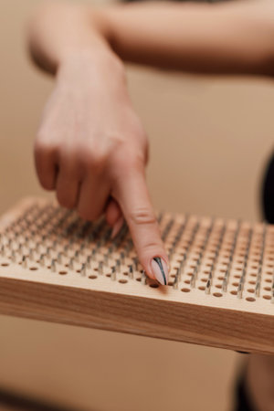 A woman's finger on a sadhu board. Woman holding a board in the hands of a sadhu. High quality photoの写真素材