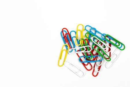 Multi-colored paper clips on a white background, filmed with a camera from above. Banners for advertising. High quality photoの写真素材