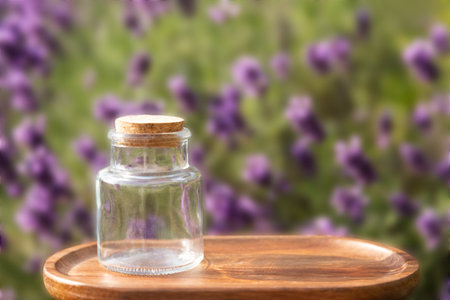 Empty Glass Jar with Cork Lid on Wooden Tray with Lavender Backgroundの写真素材