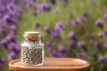 Glass Jar Filled with Dried Lavender on Wooden Tray with Lavender Background Outdoorsの写真素材