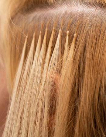 The process of blonde hair extensions. Beauty salon. Hair encapsulation. Hair extensionsの写真素材