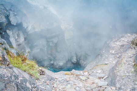 Smoking hole in the ground - steam rising over geothermal area in mountains near Rotoruaの写真素材