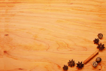 Festive background with spices arranged onf a wooden chopping board. Start anise, cinnamon quills, whole nutmegの写真素材