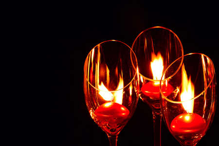 Three red candle lights in glasses on black background. Concept of Holiday Season and memoryの写真素材