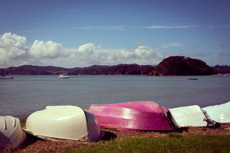 Retro style photo of upturned rowing boats on an empty beachの写真素材