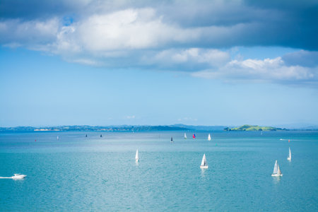 Small sailing boats scattered over calm waters of Auckland Harbour on a glorious winter day. North Island, New Zealand.の写真素材