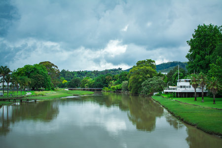 Picturesque summer landscape with a calm river lazily flowing between green riverbank. Peaceful...