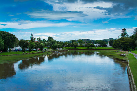 Picturesque summer landscape with a calm river lazily flowing between green riverbank. Peaceful...