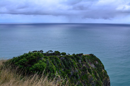 Narrow promontory rising high above over calm blue waters of Tasman Sea. Te Toto Gorge Lookout,...