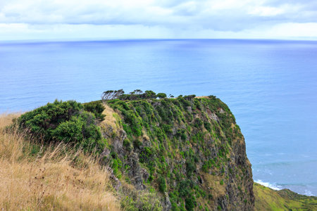Narrow promontory rising high above over calm blue waters of Tasman Sea. Te Toto Gorge Lookout,...